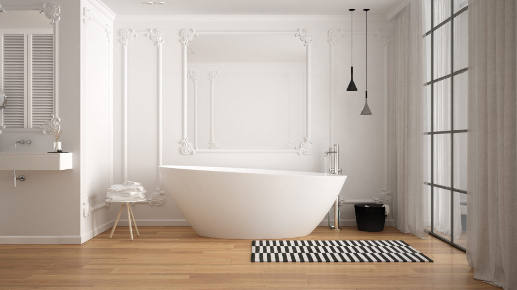modern white bathroom with crown molding, a bathtub, and a black and white striped rug