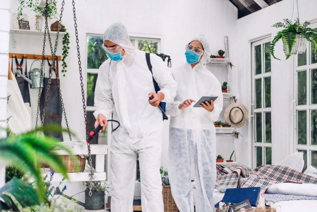 two exterminators spraying a home for bugs